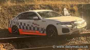 You can't park there! Police patrol car left stranded across a train line after high-speed pursuit in Mount Druitt takes a wrong turning