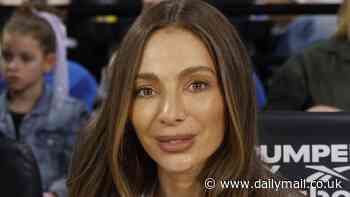 Nadia Bartel turns heads in figure-hugging ensemble as she attends NBL match with sons in Melbourne