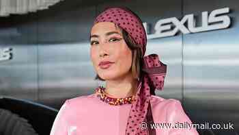 Melissa Leong puts on a very quirky display in a bright pink satin dress with beaded rainbow cuffs as she attends Crown Oaks Day in Melbourne