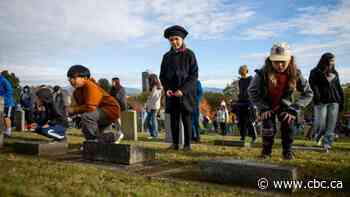 Children lay poppies on veterans' headstones in B.C. as part of No Stone Left Alone initiative