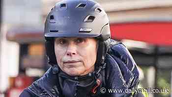 Minnie Driver ditches her Hollywood glam for a safety helmet and hi-vis jacket as she hops on a Lime bike in London