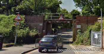 Van becomes stuck under low railway bridge