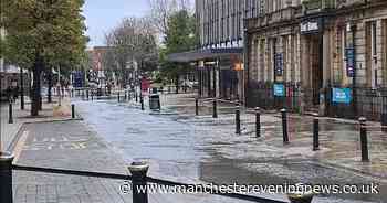 Town centre street flooded as pavement and shopping centre entrance taped off