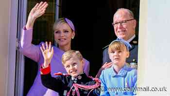 Princess Charlene and Prince Albert are joined by their mini-me twins Gabriella and Jacques, nine, as they wave from the balcony to celebrate Monaco National Day