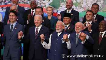 Biden finally makes it to his G20 group photo with a little jog... after emerging behind a palm tree to miss the last