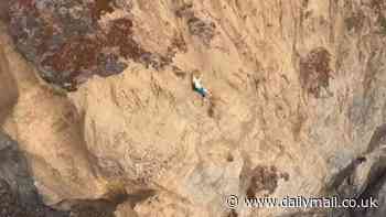 Nail-biting moment hiker hangs off edge of cliff before dramatic rescue