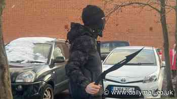 Shocking moment masked thug in balaclava brandishes two machetes outside school in Nottingham