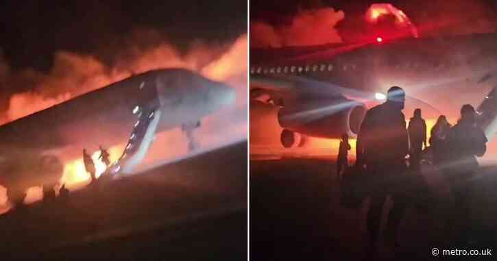 Passengers flee down emergency slides after plane burst into flames on landing