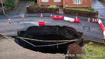 Aerial images reveal inside huge 50ft sinkhole that has opened up on quiet residential road - as 30 homes are evacuated