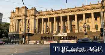 Police vow to find men who held antisemitic sign on steps of Victorian parliament