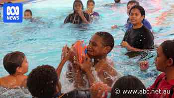 Young footy lovers take game into the water to beat the heat