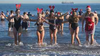 That's one way to burn off the Christmas calories! Swimmers take advantage of mild temperatures to enjoy a Boxing Day dip (but it still looks chilly enough)