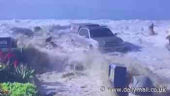 Thunderous moment powerful wave crashes over sea wall sweeping away beachgoers and truck in its path