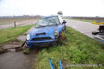 Auto belandt op de kop onderaan de dijk