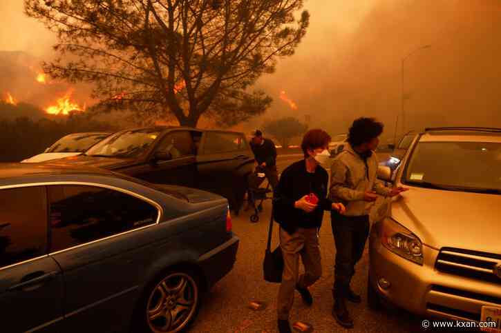 Wildfires burn out of control across Los Angeles area and kill 2 as thousands flee homes