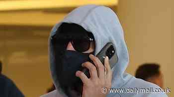 Major American rapper goes incognito as he arrives at Perth Airport - can you guess who it is?