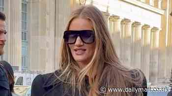 Rosie Huntington-Whiteley looks effortlessly chic in a black trench coat as she steps out during PFW