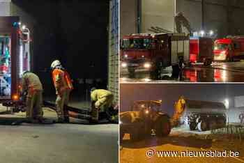 Brandweer blust ’s nachts afvalberg in bedrijf industriezone, tractoren voeren water aan