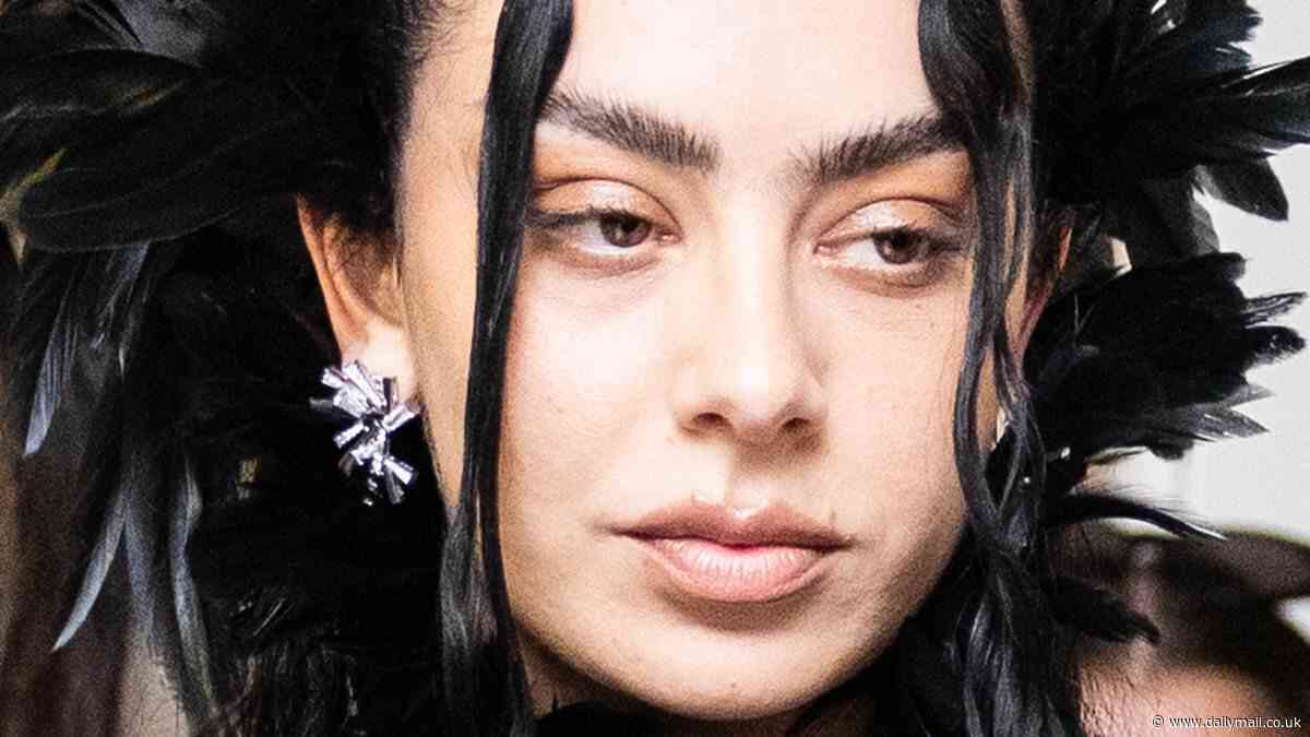 Charli XCX flashes her underwear in a sheer skirt teamed with leather thigh-high boots for a very daring display at the Met Gala 2025