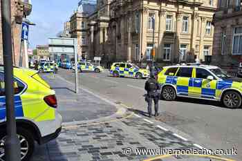 Armed police officers block city centre road and carry out raid