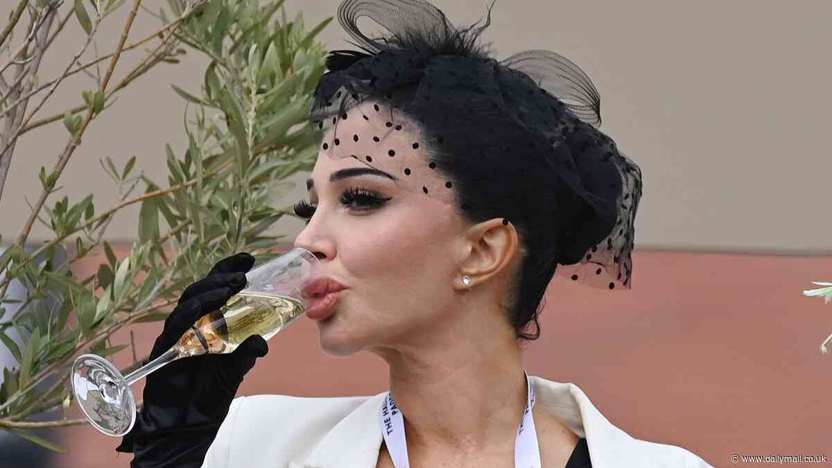 Tulisa sips on champagne in a white and black ensemble as she watches Chester races on Ladies Day