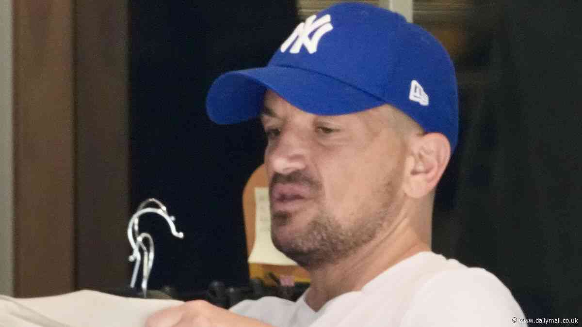Mysterious boy: Peter Andre tries to go incognito in Australia as he is slammed for 'vile' Instagram post - and bizarrely uses a fake name at the dry cleaner