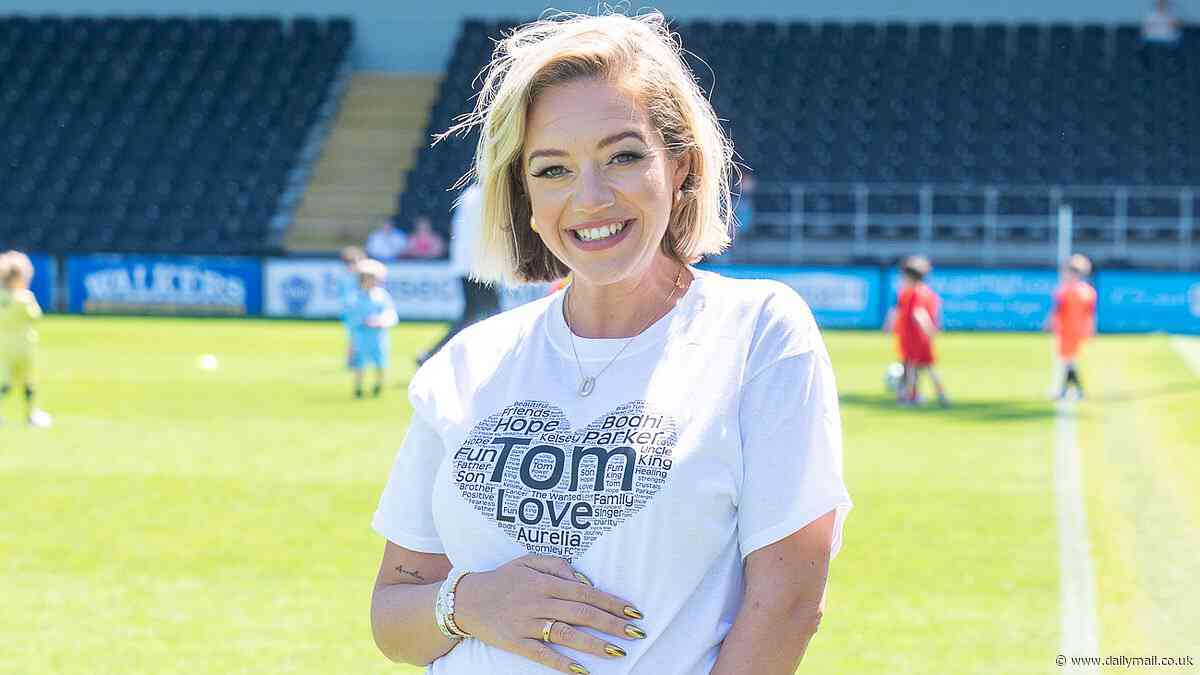 Pregnant Kelsey Parker cradles her baby bump as she leads stars at annual charity football match in memory of her late husband Tom