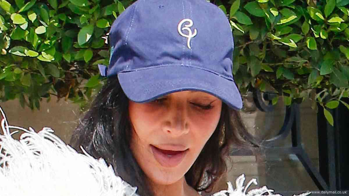 Kim Kardashian makes bizarre fashion choice as she teams busty feathered gown with a baseball cap for lunch with suited and booted Kris Jenner after testifying in jewellery heist trial