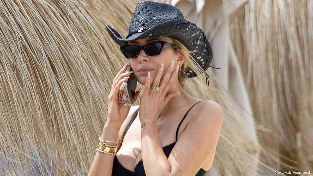 Olivia Attwood shows off her incredible figure in a busty black bikini teamed with a straw cowboy hat as she soaks up the sun in Tenerife