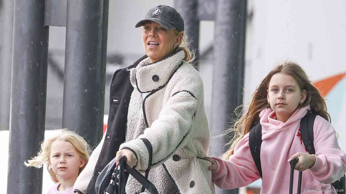 Carrie Bickmore cuts a casual figure in a cosy fleece coat as she jets off from Perth Airport on girls' trip with her two young daughters
